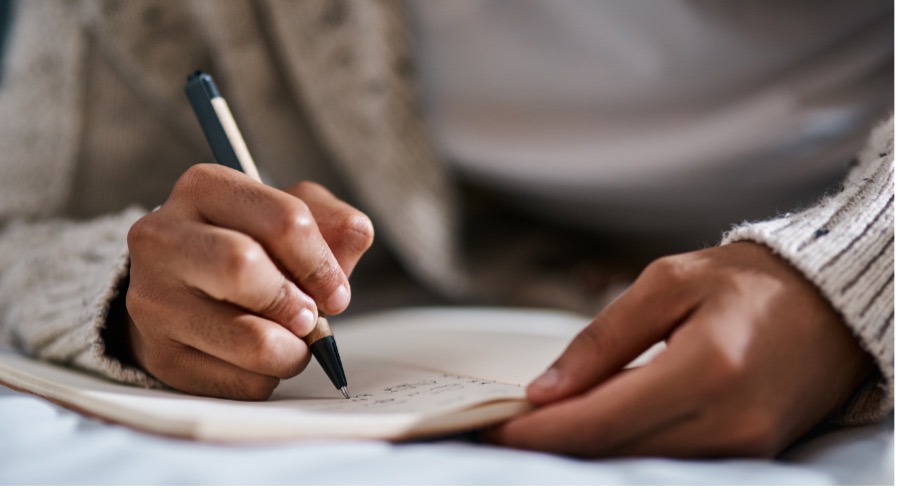 photo of hands holding a notebook and pen 
