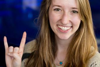 Student giving the hookem sign