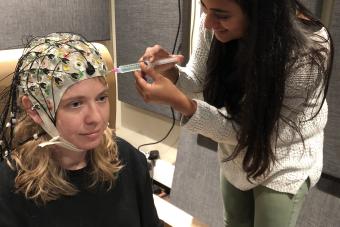 Graduate student Maansi Desai piloting an EEG study with Dr. Liberty Hamilton