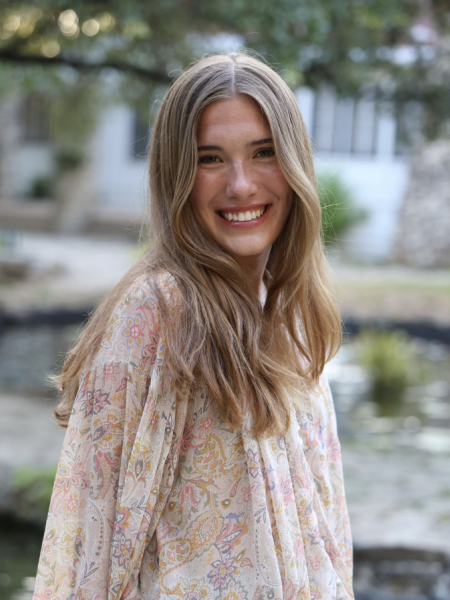 Picture of Sophia wearing a white shirt in front of a scenic background