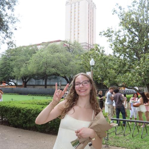 Picture of Harley wearing a yellow dress holding flowers. 